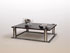 Table basse, mod&egrave;le �vague� en fer brut et acier bross&eacute;, dessus en fr&ecirc;ne massif fum&eacute;.
